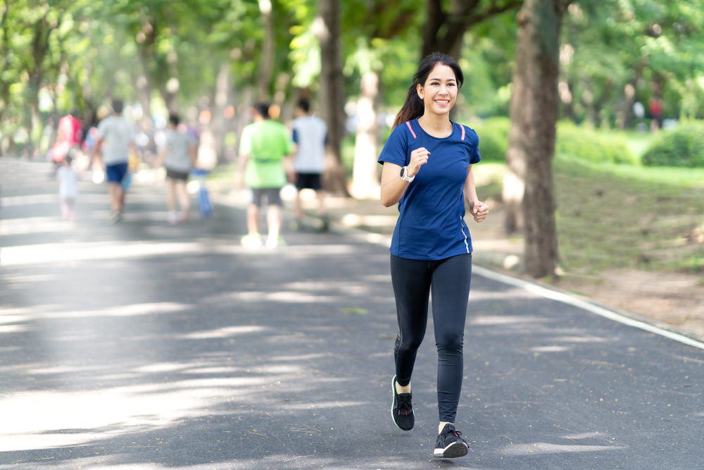 A young woman running in a park. Bangkok run clubs are a good way to run with others.